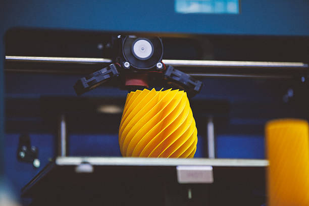 Bright yellow spiral 3D print on a printer bed